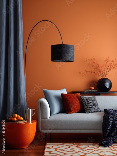 Modern living room with burnt orange wall, grey sofa and blue accents