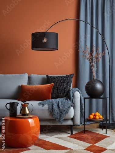 Modern living room with burnt orange wall, grey sofa and blue accents