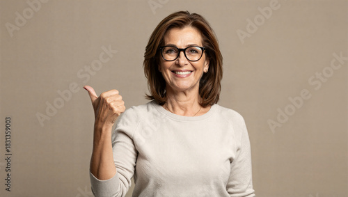 Positive gesture woman giving thumbs up studio setting portrait photography warm atmosphere close-up perspective