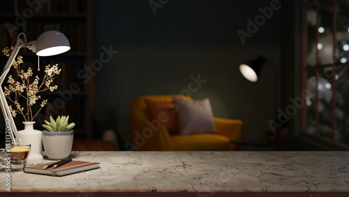 Fototapeta Naklejka Na Ścianę i Meble -  Books and coffee under lamp light on marble stone counter table across sofa chair in a dim lit room.