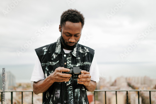 Man adjusting camera settings on rooftop