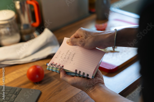 Anonymous Young Man Prepares Grocery List in Modern Kitchen