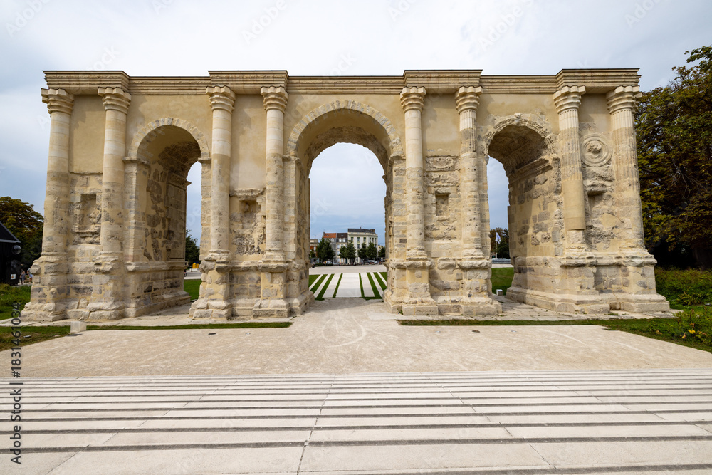 Obraz premium Reims, Marne, Grand-Est, France, August, 28th, 2025, Champagne Area, BArchway leads outward, Scenic classical archway stretching over manicured lawns and treelined promenade with diffused