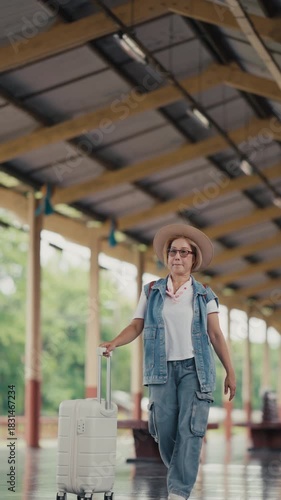Mature female traveler waiting at train station platform