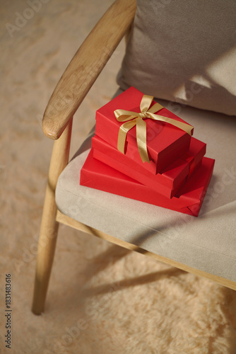 Red gift boxes with gold ribbon on a chair