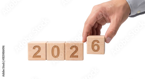 Hand completing the year 2026 with wooden blocks. Business concept for new year goals, isolated on transparent background
