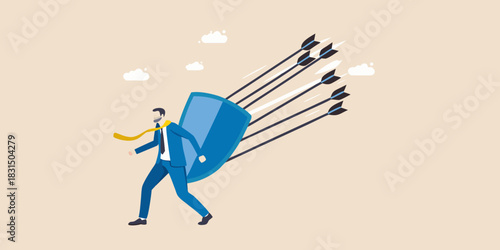 Businessman holding a shield deflecting arrows