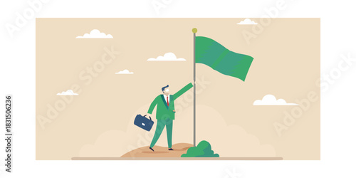Businessman planting a green flag on a hilltop