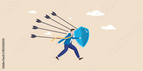 Businessman defending against arrows with a shield