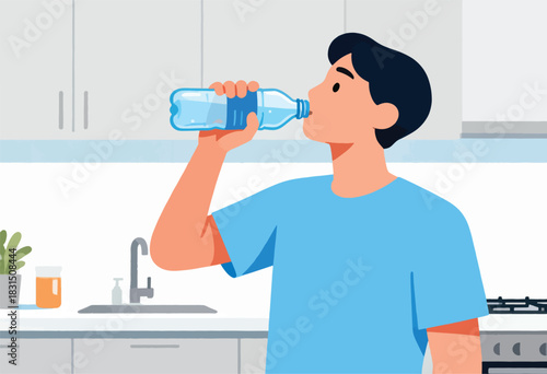 A man in a blue shirt drinks water from a plastic bottle, kitchen in background