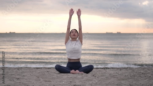 夕方の海辺でヨガをする女性