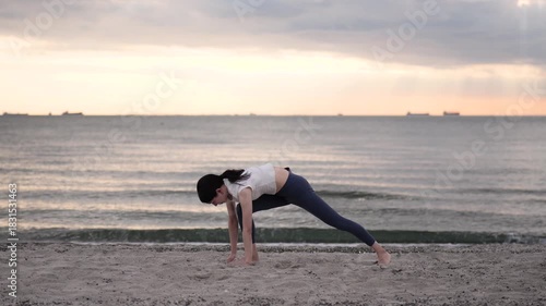 夕方の海岸でヨガをする女性