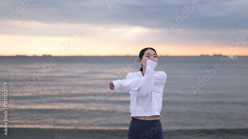 夕方の海辺でストレッチをする女性のサークルショット