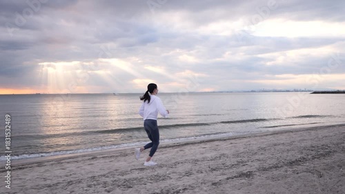 夕方の海辺でジョギングする女性する女性
