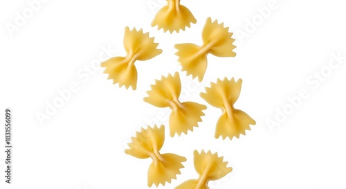 A close up shot of several pieces of farfalle pasta scattered on a plain white background surface