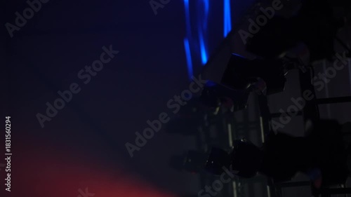 Vivid concentrated beams from modern stage lighting equipment illuminate the venue with deep blue tones, creating immersive visual effects for a large-scale indoor event production