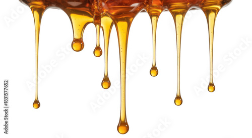 Thick golden honey dripping in viscous strands and droplets isolated on a transparent background