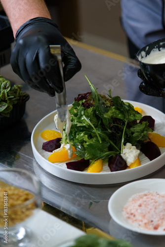 the chef prepares a salad with beetroot, oranges, strachatella cheese and flax seeds