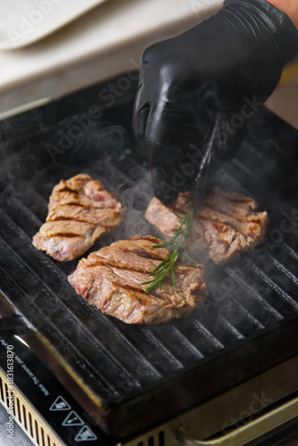 Chef cooks grilled beef medallions