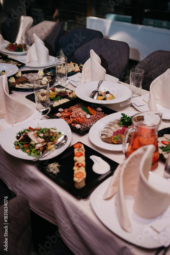 A table set for a banquet or celebration in a restaurant with a variety of dishes