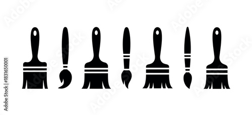 A collection of various black paintbrushes and artist brushes are displayed in a row against a white background.