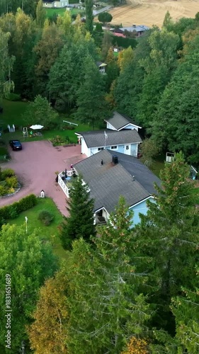 Wallpaper Mural Vertical drone shot circling a house with kids playing on the yard, fall day Torontodigital.ca