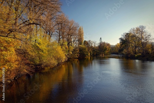Autumn landscape with river and setting sun. Concept for nature and autumn time