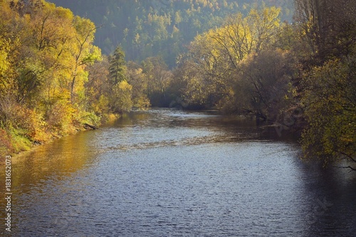 Autumn landscape with river and setting sun. Concept for nature and autumn time