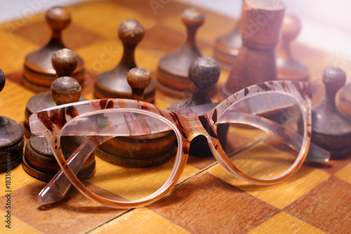 Old wooden chess set and glasses. Retro.