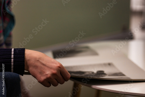 Close-up photograph of human hands flipping through a magazine. Clear details of the paper, texture, and page movement. Perfect for lifestyle imagery, education, reading habits, print media
