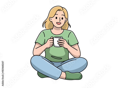 A smiling woman sits cross-legged holding a white mug of a beverage in her hands.