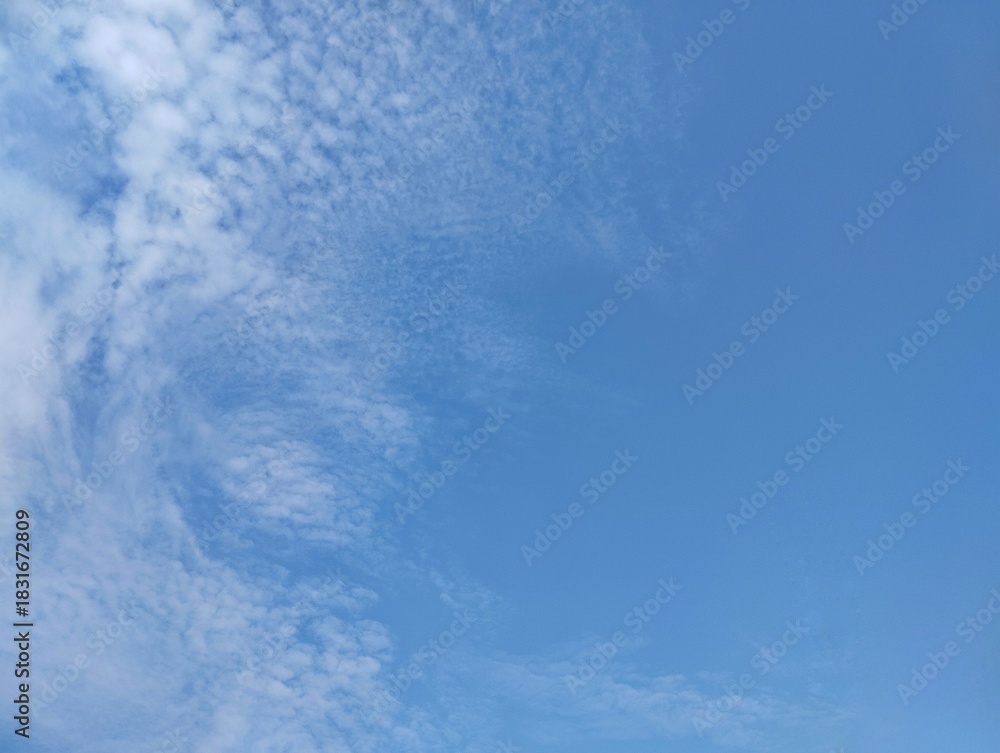 Fototapeta premium clear blue sky with a few clouds. The sky is very bright and the clouds are scattered throughout. Copy space 