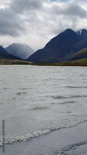 Slow-motion vertical video of Altai Lake Akkul. View towards the Sofiysky Glacier on the South Chuya Ridge.