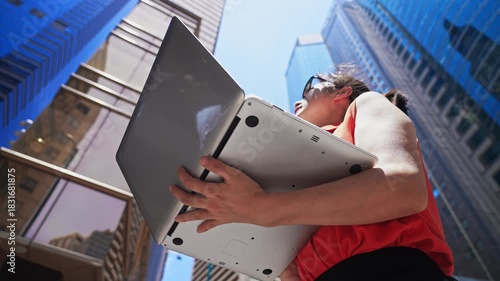 Businesswoman using laptop outside the office building in HONG KONG