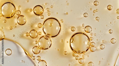 Macro shot of shimmering golden liquid bubbles, creating an abstract and vibrant texture, ideal for beauty, science, or cosmetic themes and luxurious product backgrounds