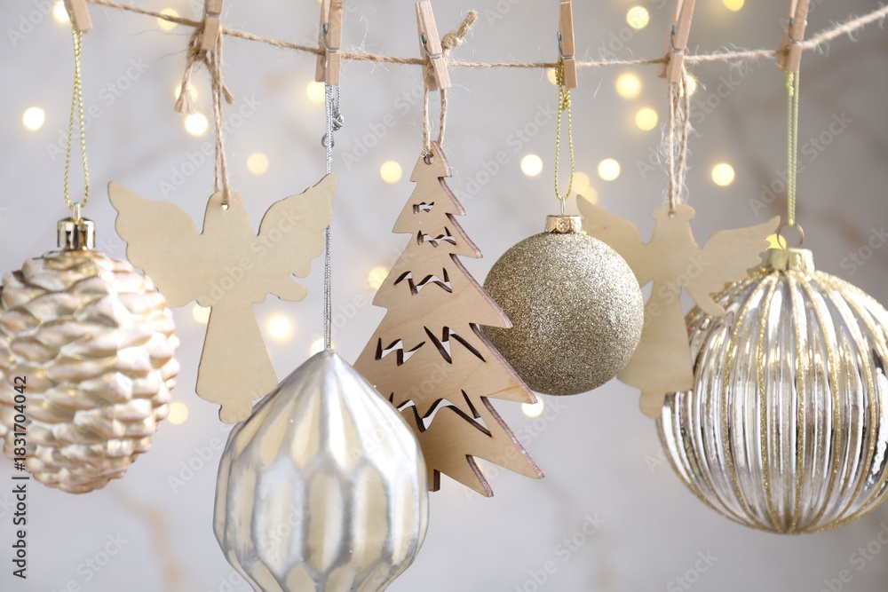 Naklejka premium Beautiful Christmas decor hanging on string against blurred lights, closeup