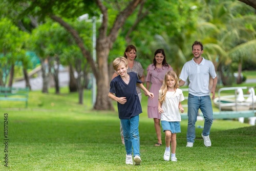 Happiness family outdoor joyful enjoying nature bonding in nature intergenerational happiness. Multigenerational family walking in park outdoor fun lifestyle relaxing smiling walking connection