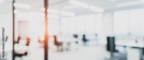 Bright abstract office interior with blurred furniture and light flares, complemented by gentle highlights and soft reflections that create a warm, modern, and visually balanced workplace environment.