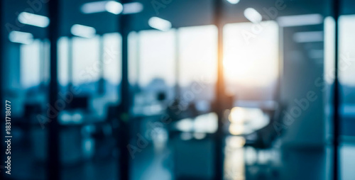 Blurred modern office interior with bright window light and blue tones, enhanced by soft diffused lighting that adds calm atmospheric depth to the clean workspace