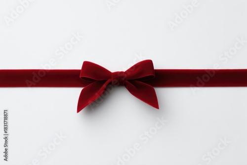 Elegant red velvet bow resting on minimalistic white background,