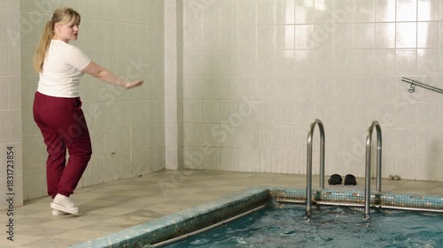 supportive atmosphere, therapeutic water, mobility improvement. Preparing for hydrotherapy, man with disability is guided by medical professional in nurturing environment.