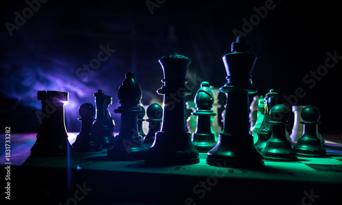 Chess board game concept of business ideas and competition. Chess figures on a dark background with smoke and fog.
