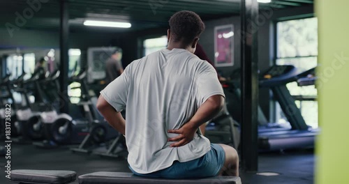 Gym, athlete and man with back pain, sore and training injury after exercise routine or inflammation. Workout, accident and person with muscle sprain, massage and joint ache in health club or fitness