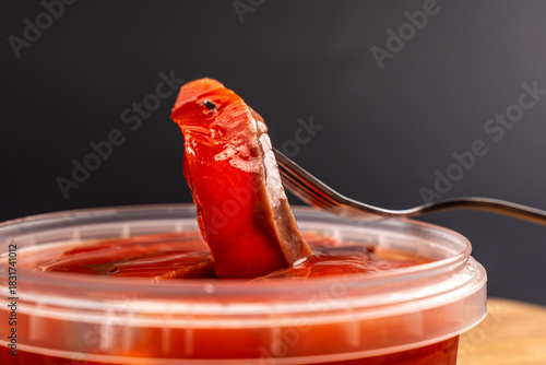 Salted Salmon Fillet Slices in Plastic Container on Black Background
