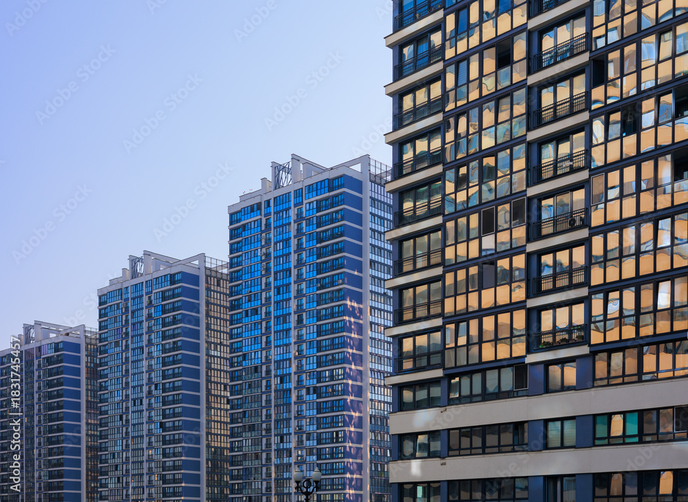Obraz premium Cityscape on a summer day, modern buildings and houses against the blue sky 
