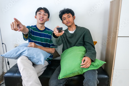 Excited Teens Channel Surfing Together Indoors