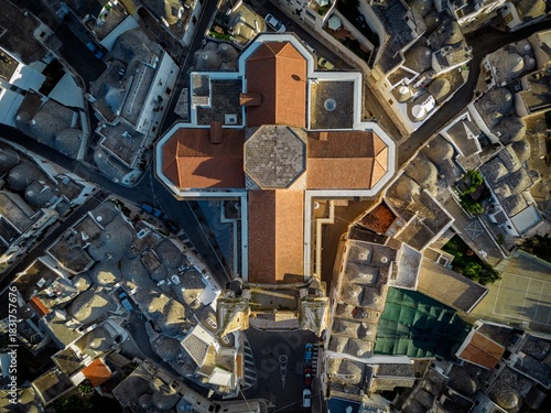 Aerial view of the church of Saint Anthony of Padua standing as a cross amidst the town's traditional conic architecture, Alberobello, Apulia, Italy.