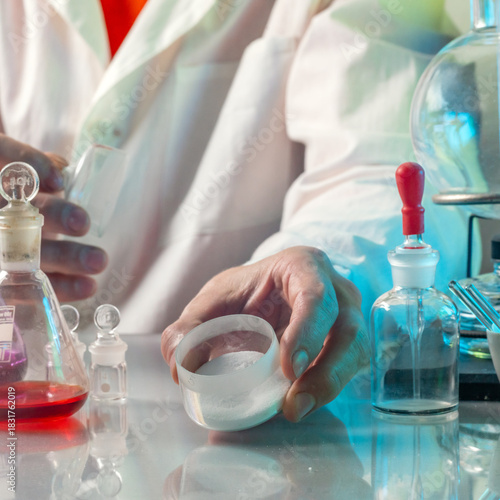 A scientist in a white coat works in a chemical laboratory