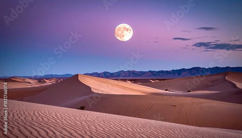 Fototapeta Naklejka Na Ścianę i Meble -  A full moon illuminates the sand dunes of a desert landscape at dusk, with a colorful sky.