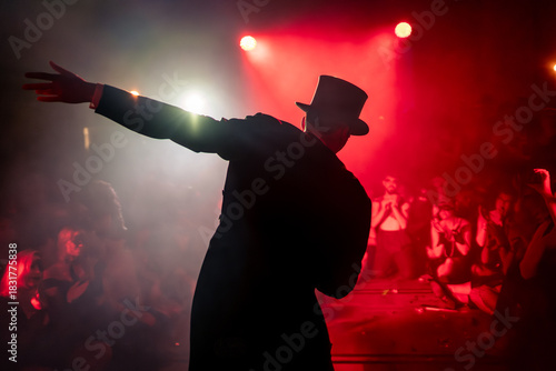 Foto Performer wearing a tailcoat, top hat, and garters stands in the fog during a show, surrounded by an enthusiastic audience